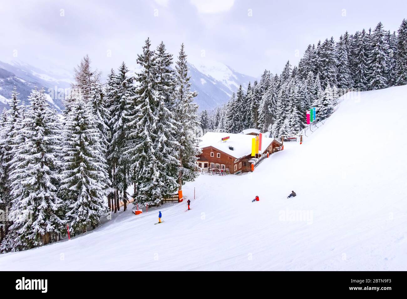 Österreichische Alpen, Skipiste Winter Berglandschaft, Schneestwald und Holzhaus Blick von oben Stockfoto