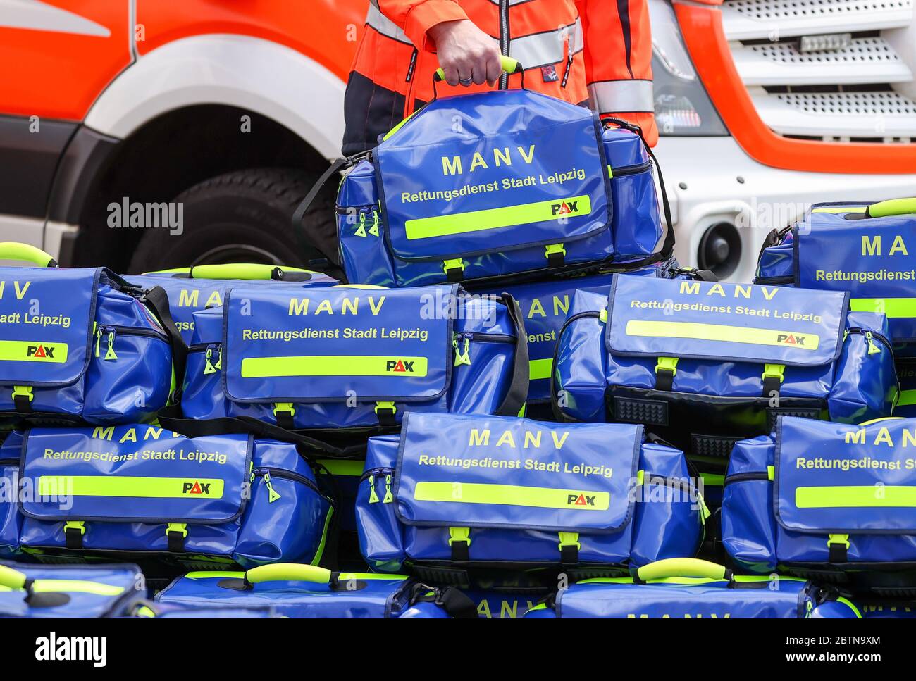 27. Mai 2020, Sachsen, Leipzig: Ein Mann hält eine spezielle Tasche für sogenannte "Massenunfall- und Krankheitsfälle" (MANV) vor einem Krankenwagen. Im Inneren des Beutels befinden sich unter anderem spezielle Verbandbinden zum Abhalten von Blutungen bei schweren äußeren und inneren Verletzungen sowie Markierungen für Menschen mit unterschiedlichem Schweregrad. Bei einem Massenunfall sind zunächst nur wenige Rettungsteams mit einer großen Anzahl von Verletzten konfrontiert. Das Überleben von so vielen Patienten wie möglich kann durch die Sortierung und Kennzeichnung der verschiedenen Grad der Verletzung und dann Organisation Behandlung gewährleistet werden Stockfoto