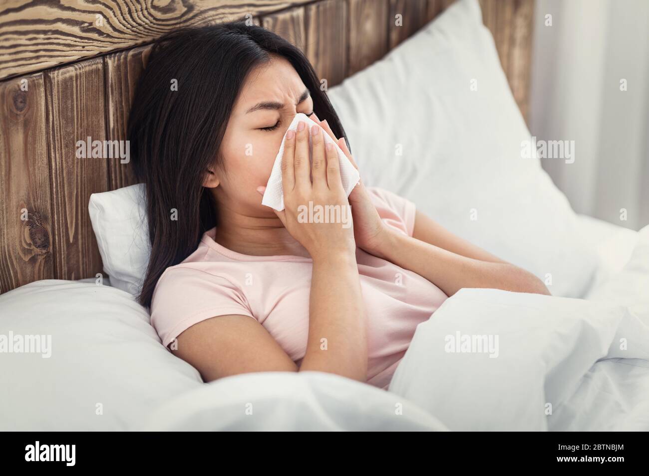 Kranke Chinesische Frau Weht Nase In Gewebe Im Bett Liegen Stockfoto