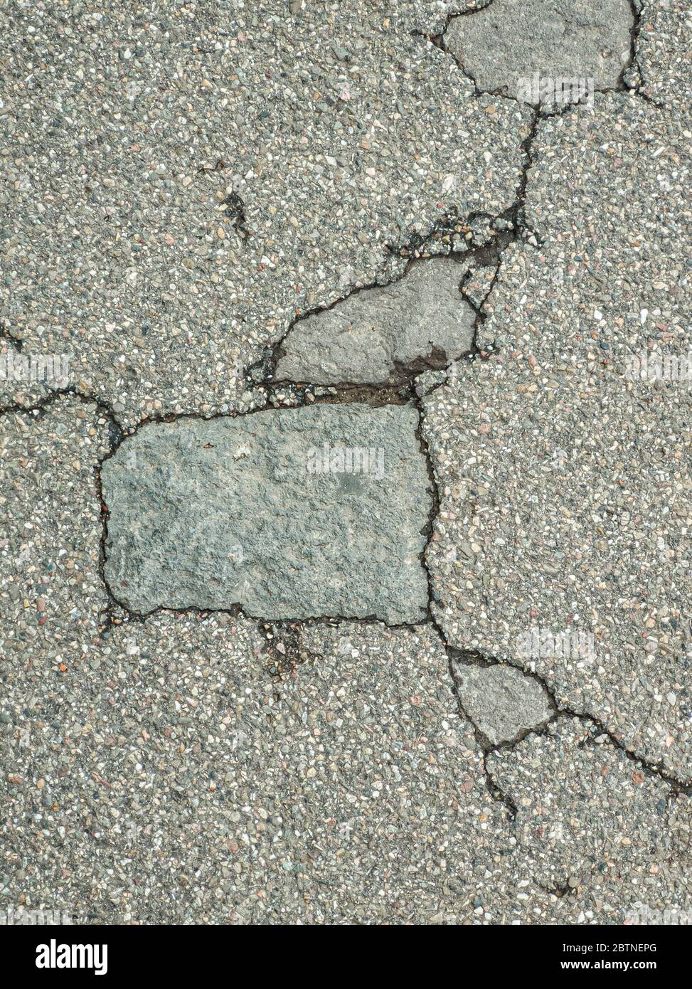 Alte Straße - Oberfläche von grauem Asphalt geknackt - Textur Nahaufnahme Stockfoto