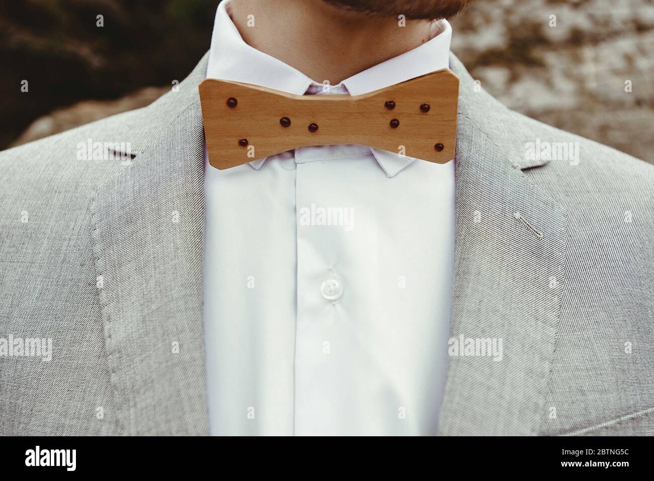 Stilvolle Holzschleife des Bräutigams, Nahaufnahme von Hintergrundfelsen in den Bergen, luxuriöse Boho-Hochzeit Stockfoto