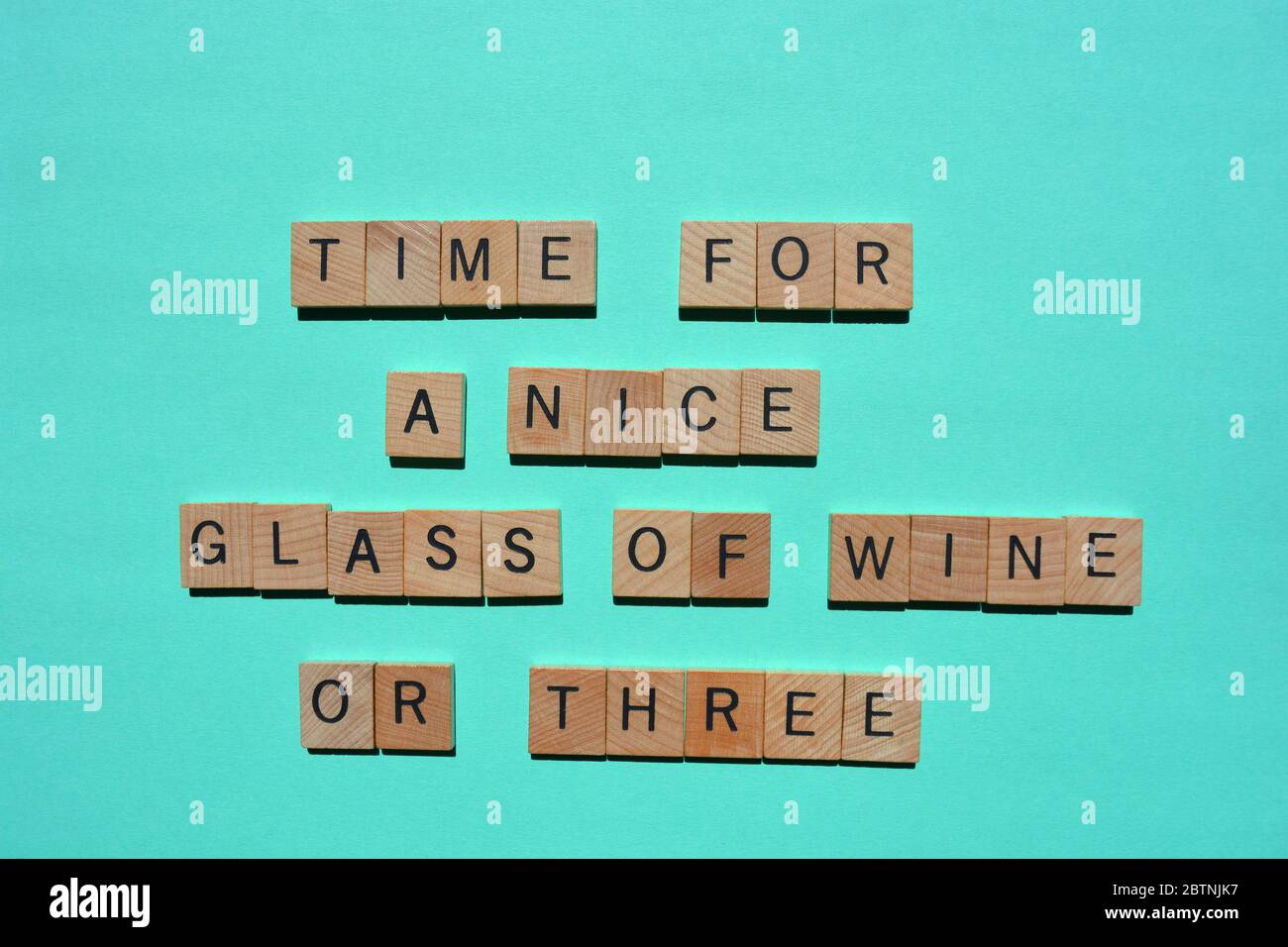 Zeit für EIN schönes Glas Wein oder drei, Wörter in hölzernen Buchstaben, isoliert auf türkisfarbenem Hintergrund Stockfoto