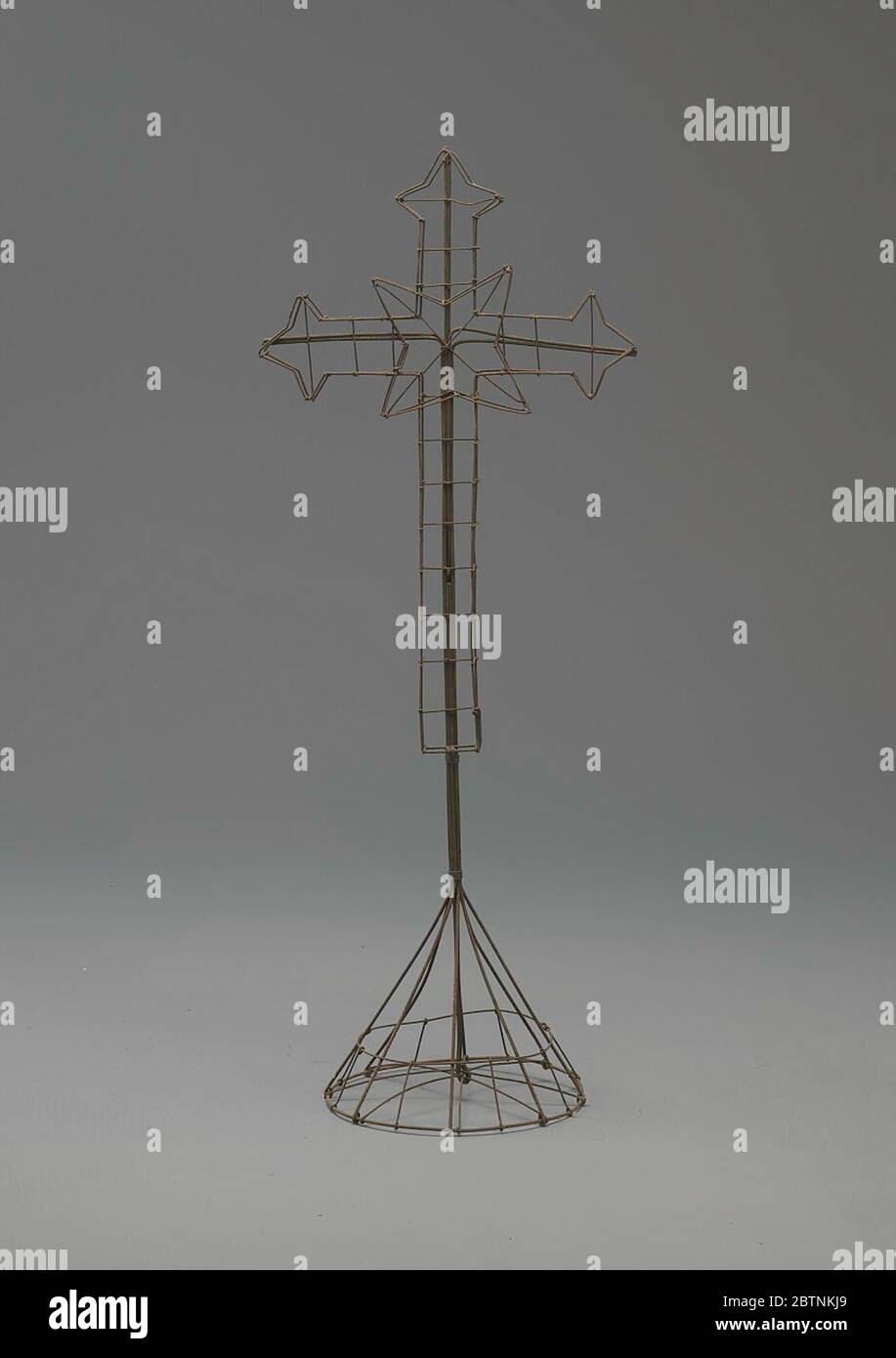 Drahtrahmen Kreuz Stern Mitte auf Stativ. Das Kreuz war einer der am häufigsten verwendeten Blumenrahmen im neunzehnten Jahrhundert, und es wird auch heute noch verwendet. Kreuze konnten groß oder klein sein und waren freistehend, auf einem Ständer oder auf dem Sarg platziert. Stockfoto