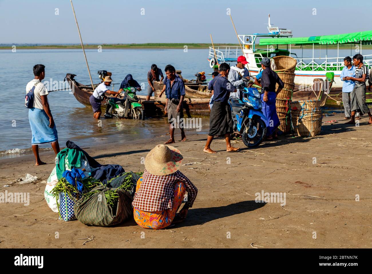 Güter und Motorräder, die von EINEM Boot auf dem Irrawaddy, (Ayeyarwady) Fluss, Bagan, Mandalay Region, Myanmar ausgeladen werden. Stockfoto