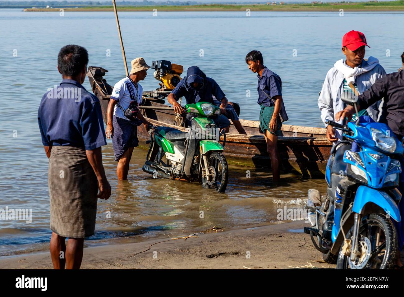 Güter und Motorräder, die von EINEM Boot auf dem Irrawaddy, (Ayeyarwady) Fluss, Bagan, Mandalay Region, Myanmar ausgeladen werden. Stockfoto