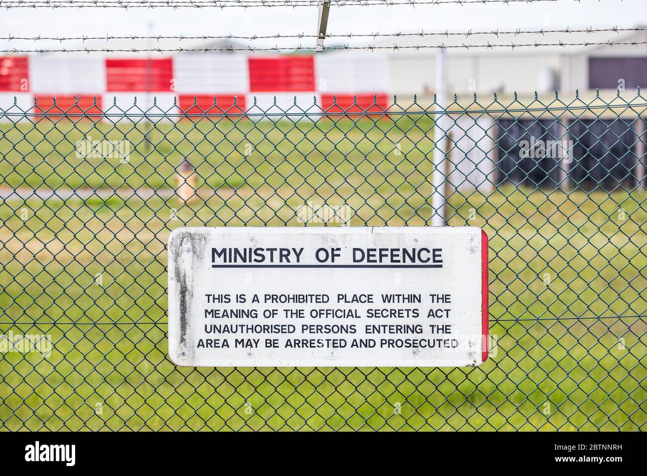 Nahaufnahme Verteidigungsministerium kein Zugang zu öffentlichen Warnzeichen hinter Sicherheitszaun: Unberechtigte Personen werden verhaftet, verfolgt, RAF Fairford, Großbritannien. Stockfoto