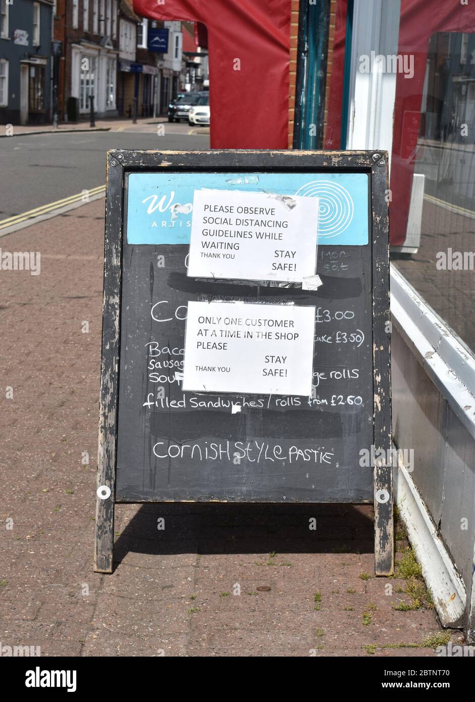 Soziale Distanzierungsmaßnahmen, die außerhalb eines Bäckerladens in Stony Stratford High Street aufgeführt sind. Stockfoto