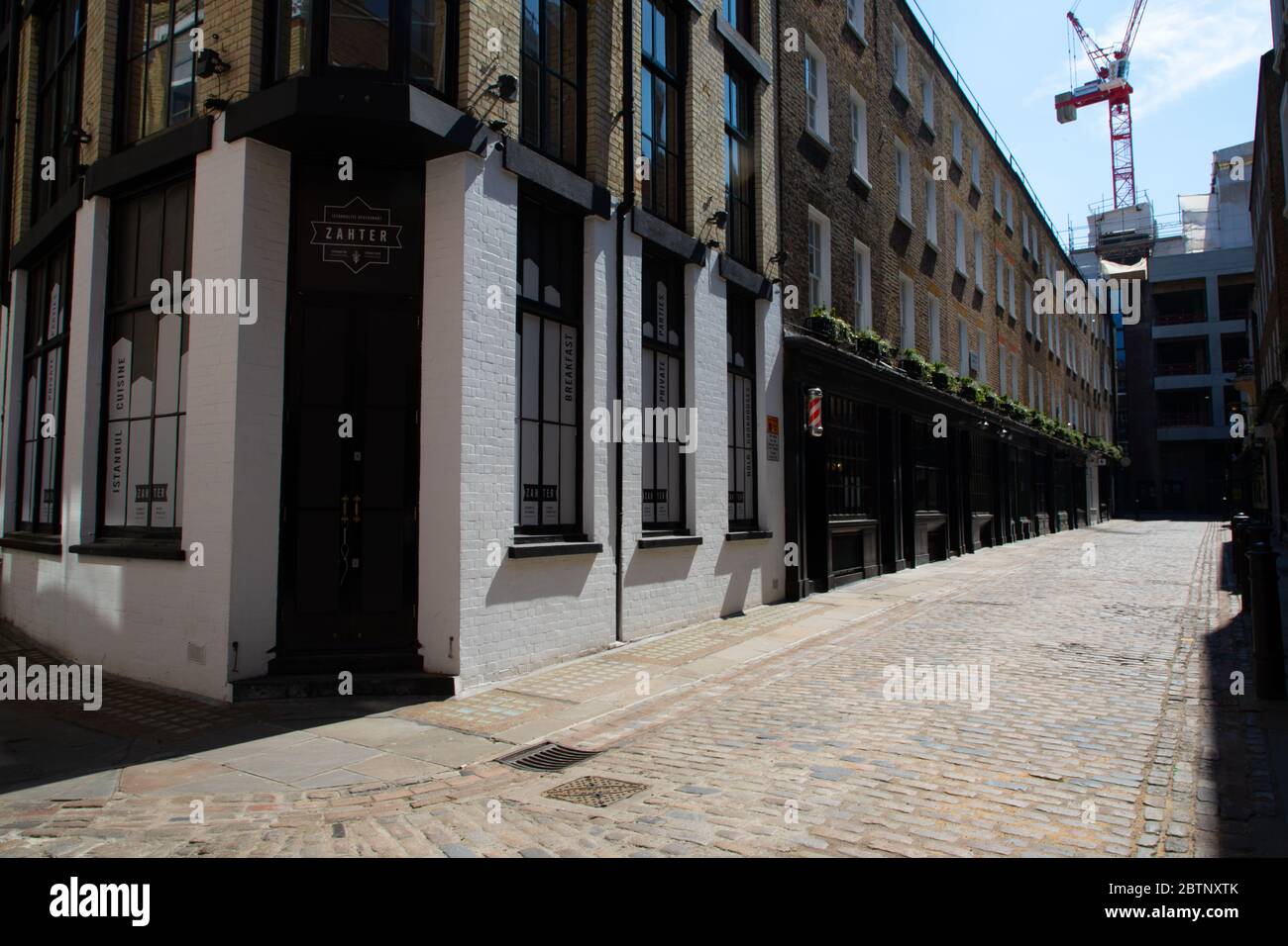 Londons Newburgh Street und Fouberts Place abseits der Carnaby Street, die voller Verkehr und Menschen ist. Die Straße ist verlassen wegen der Sperrvorschriften Stockfoto