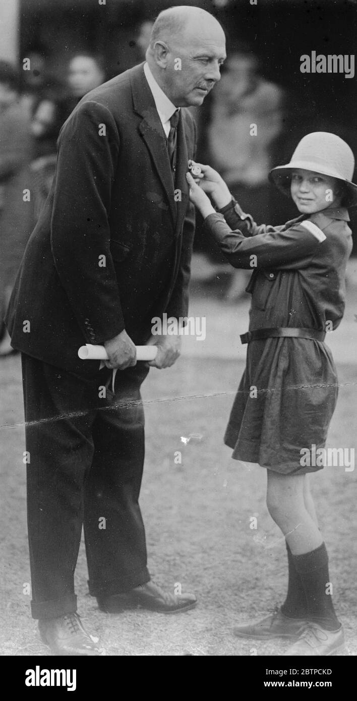 Er erhielt seinen Preis . Major General J W Sandilands , mit dem Mädchen Guides präsentiert ' Dank Abzeichen ' von einem kleinen Hong Kong Brownie . 14. Januar 1933 Stockfoto