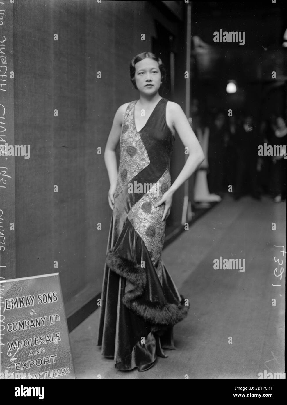 Chinesische Mädchen Schaufensterpuppe . Miss Singcha Chung, eine 22 Jahre alte Schaufensterpuppe auf der Modenausstellung in Olympia, trägt einen geflammten Samtkittel mit grüner und roter Spitze und mit ausgefransten Fuchskanten. September 1931 Stockfoto