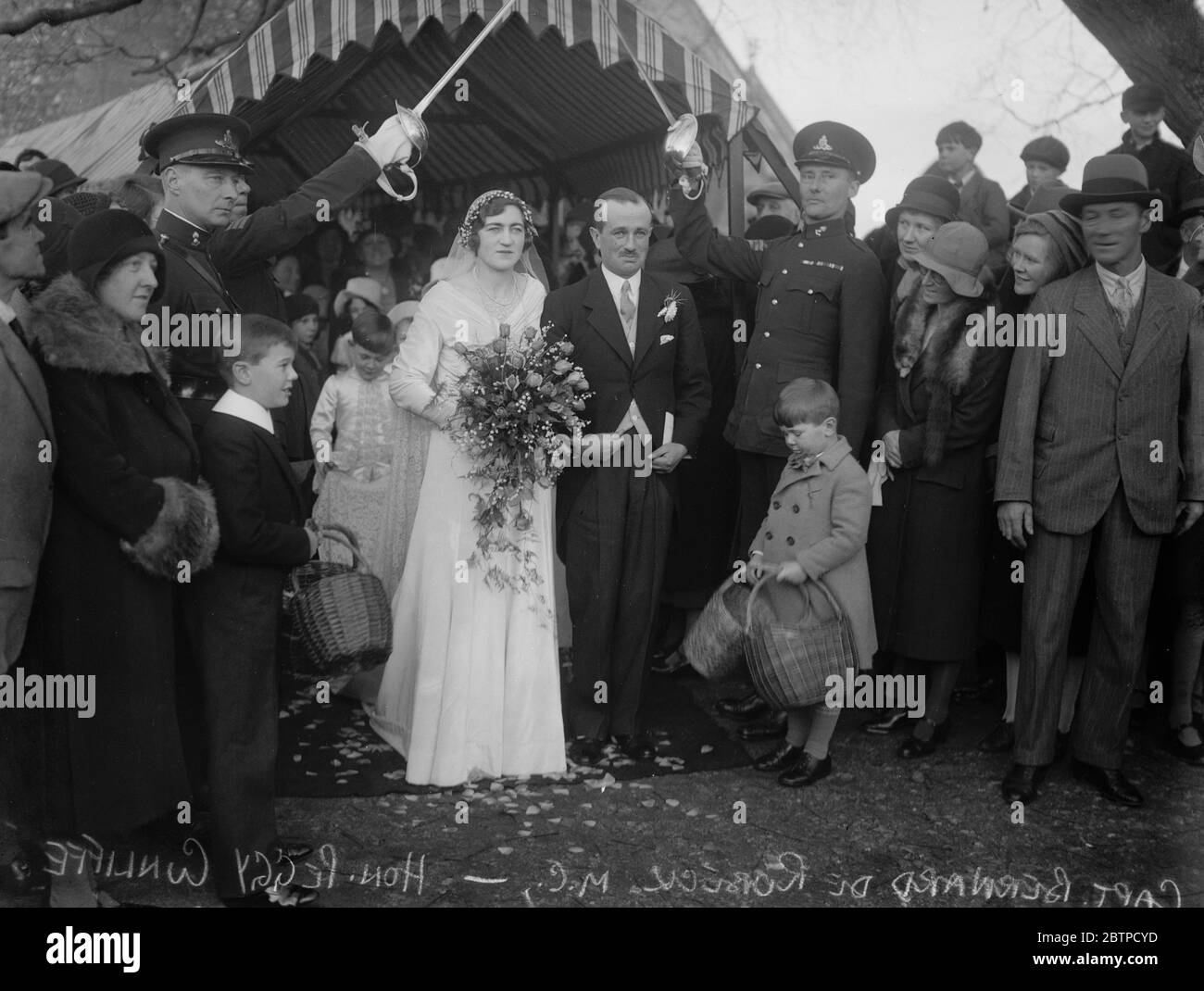 Hübsche Dorfgesellschaft Hochzeit . Die Hochzeit von Captain Bernard de Robeck MC, RA, und der Hon Peggy Cunliffe in der Pfarrkirche, Headley. Die Szene als Braut und Bräutigam die Kirche verlassen. Dezember 1932 Stockfoto