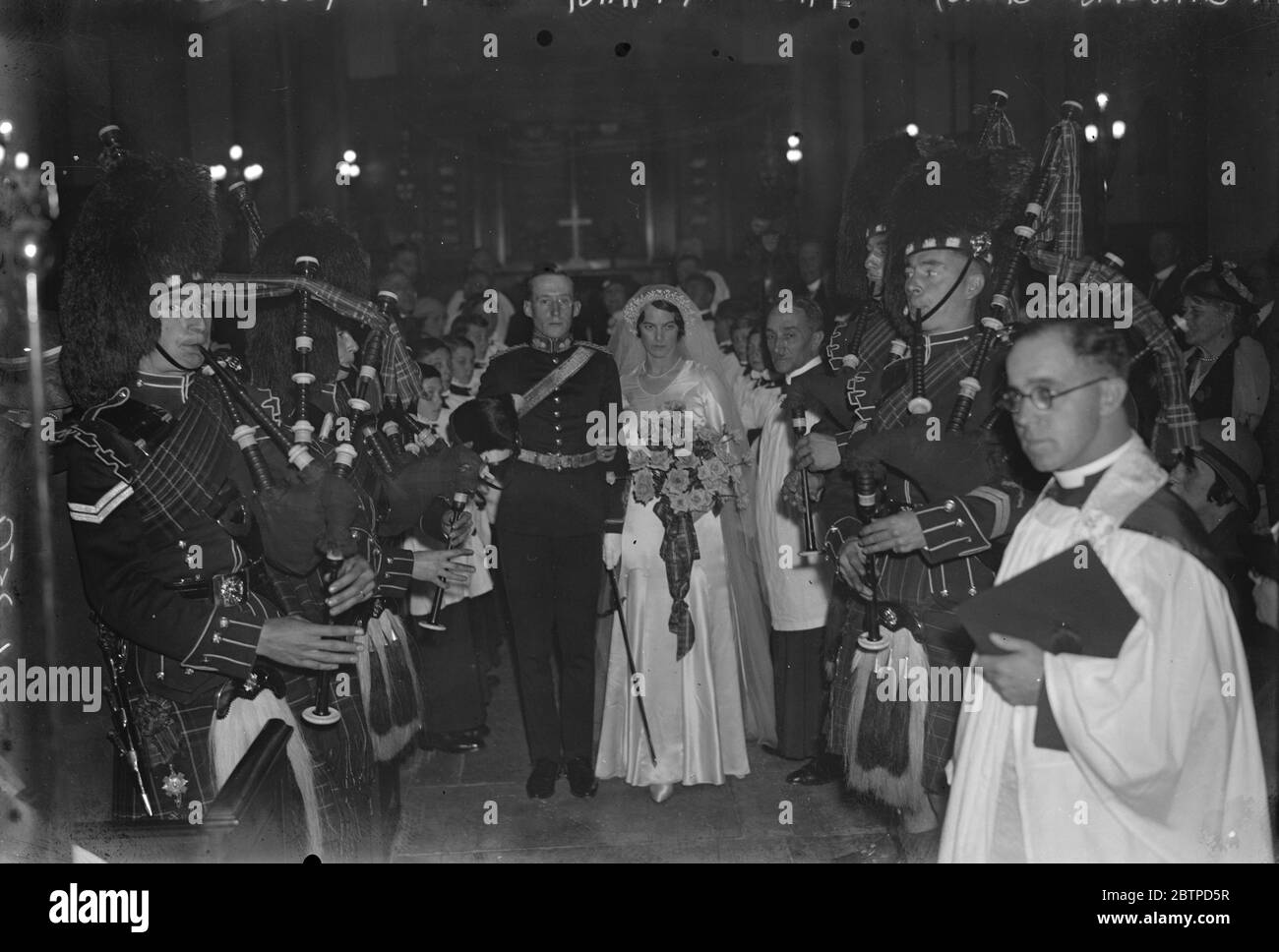 Pipers bei der Stadt Hochzeit . Pipers der 1. Bataillon Schotten Garde , die berühmte String-Band der Royal Artillery , Und der Chor von St. George 's Royal Garrison, Woolwich, waren bei der Hochzeit von Miss Nina Mary Terry und Herrn G Robert Gair, in der Kirche von St. Katherine Cree, mit St. James, Leadenhall Street. Die Braut und der Bräutigam, die den Kirchengang hinuntergehen, mit den Pfeifern an den Seiten. 23. September 1933 Stockfoto