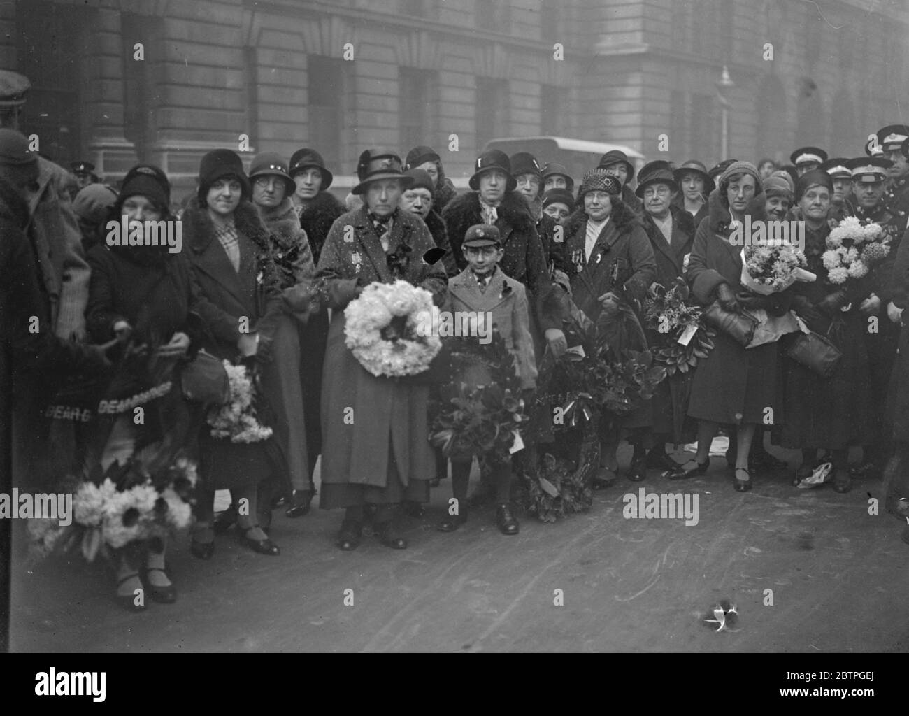 Waffenstillstandstag in London . Von einer frühen Stunde am Morgen besuchten die Menschen das Feld der Erinnerung in Westminster, um ihre Mohnblumen Pflanzen. Kriegswitwe mit dem Kranz in Westminster. Der Kranz trägt das Abzeichen der Coldstream Wachen. 11. November 1932 Stockfoto