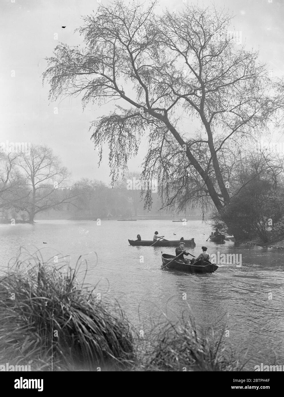 Frühling in London . Besucher Battersea Park , London Bootfahren auf dem See als Zeichen des Frühlings zeigen sich in den umliegenden Bäumen . April 1932 Stockfoto