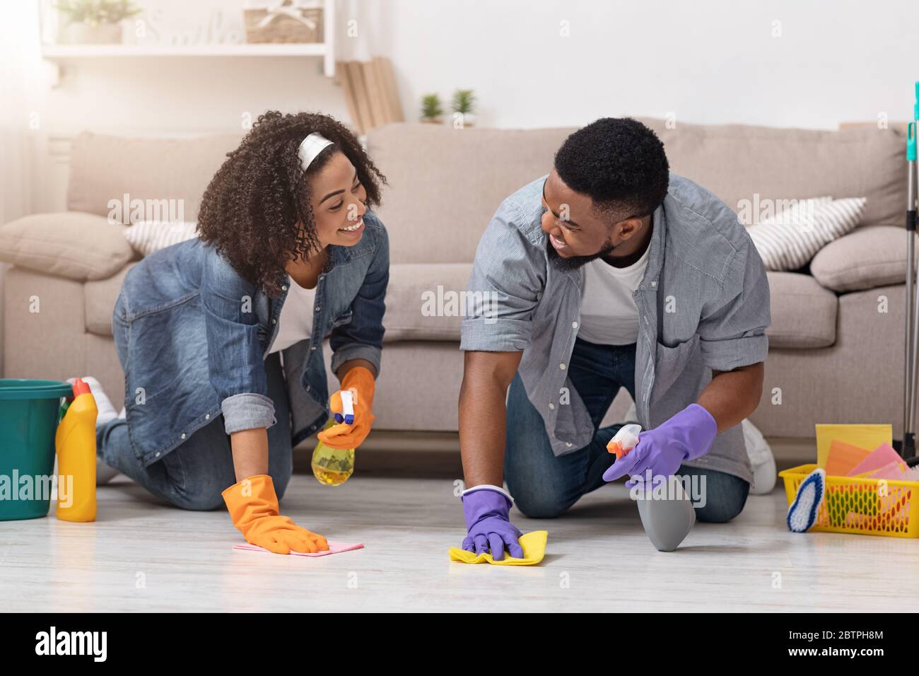Haushaltskonzept. Junge Schwarze Paar Tun Frühling Reinigung In Ihre Wohnung Zusammen Stockfoto