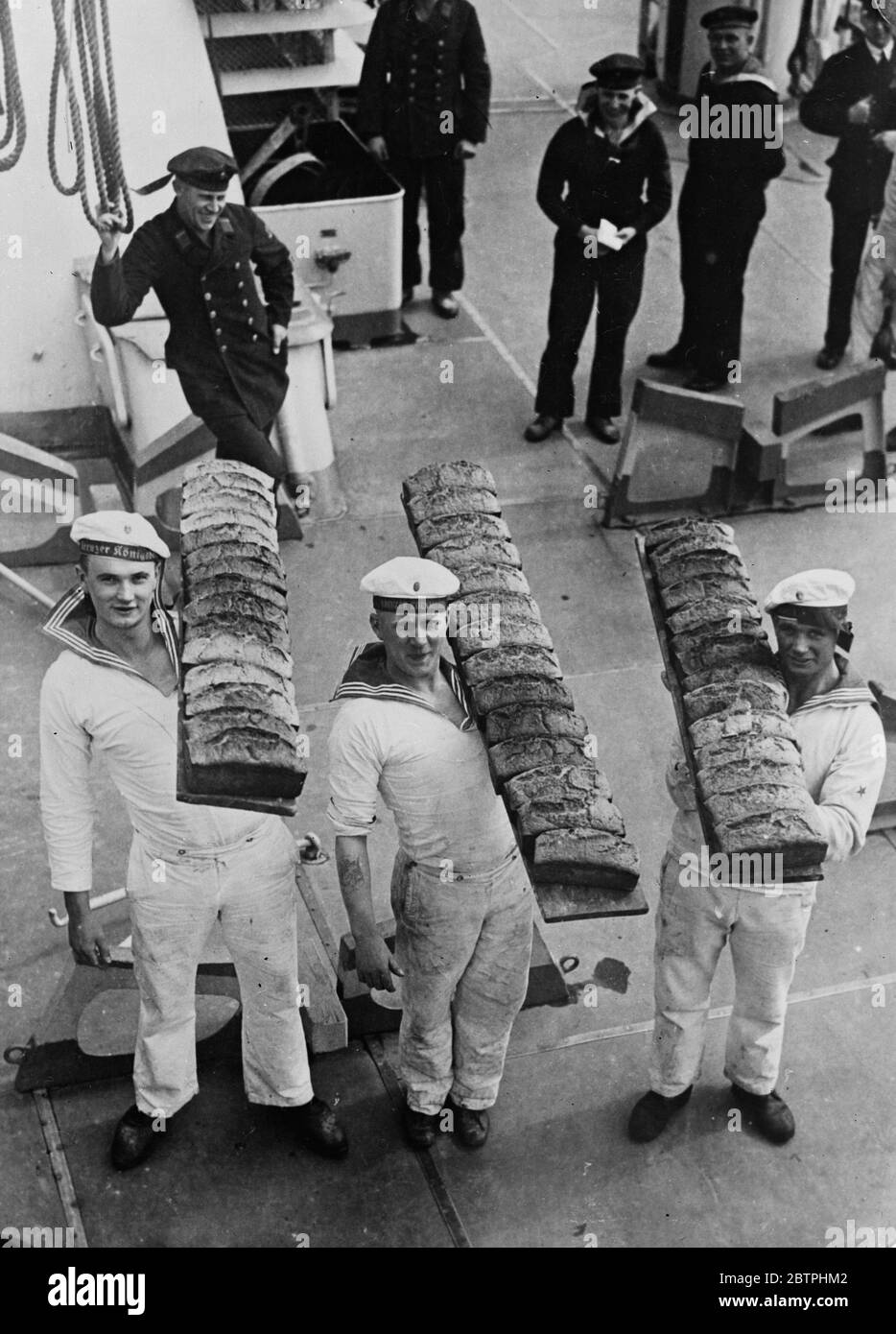 Ihr tägliches Brot. Die Schiffsbäcker des deutschen Kreuzer Koenigsberg mit der Tagesration des Schiffes an Brot, auf dem Weg von der Backstube zu den Messräumen. Februar 1932 Stockfoto