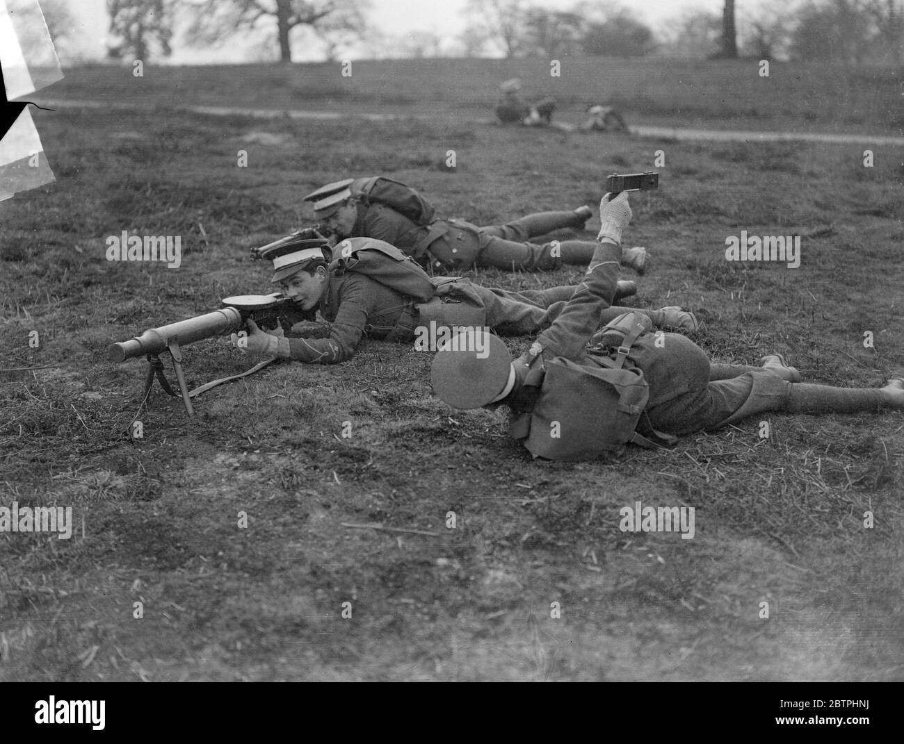 Eton College Field Day . Ein Maschinengewehr Korps, die Maschinengewehr ist Dummy, in der vordersten Linie während der Eton College Field Day Manöver in Windsor Great Park. Beachten Sie den Mann mit einer Rassel, die den Lärm ähnelt der Maschinengewehr 's Rassel macht. 17 März 1932 Stockfoto