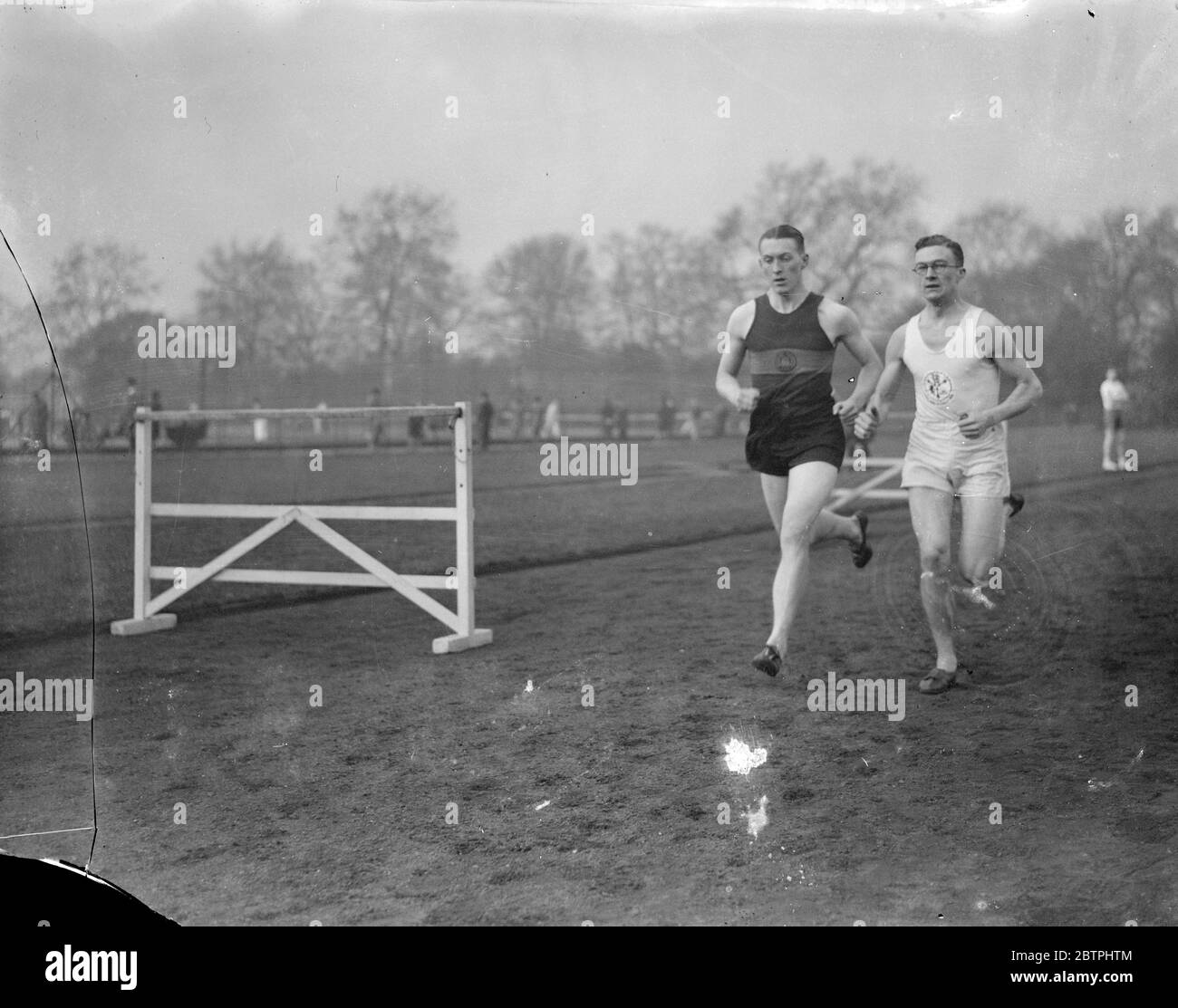 Berühmte Sportler . Tommy Scrimshaw, der All England und internationale halbe Meile Läufer (rechts) Training mit F C Ford der Belgrave Harriers auf der Battersea Park Strecke, London, für die kommende Saison. 14 März 1933 Stockfoto