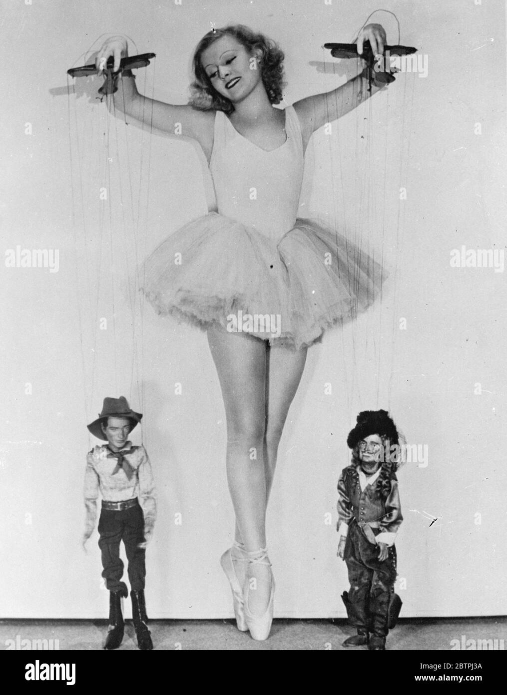 Bloße Puppen . Lillian Harvey, die in England geborene hollywood-Filmschauspielerin, demonstriert ihr Können bei der Manipulation von Marionetten von Gary Cooper und Douglas Fairbanks, zwei weiteren Lieblingsfilmen. 18 Dezember 1933 Stockfoto