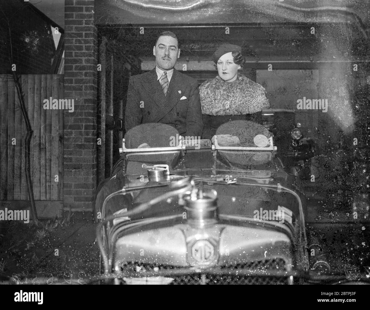 Rennfahrer engagiert . Mr R A Yallop verlobt, Juni Extremität zu verpassen und in seinem MG Sportwagen sitzen . 29 Dezember 1933 Stockfoto