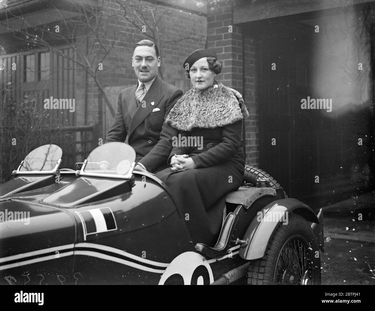 Rennfahrer engagiert . Mr R A Yallop verlobt, Juni Extremität zu verpassen und in seinem MG Sportwagen sitzen . 29 Dezember 1933 Stockfoto