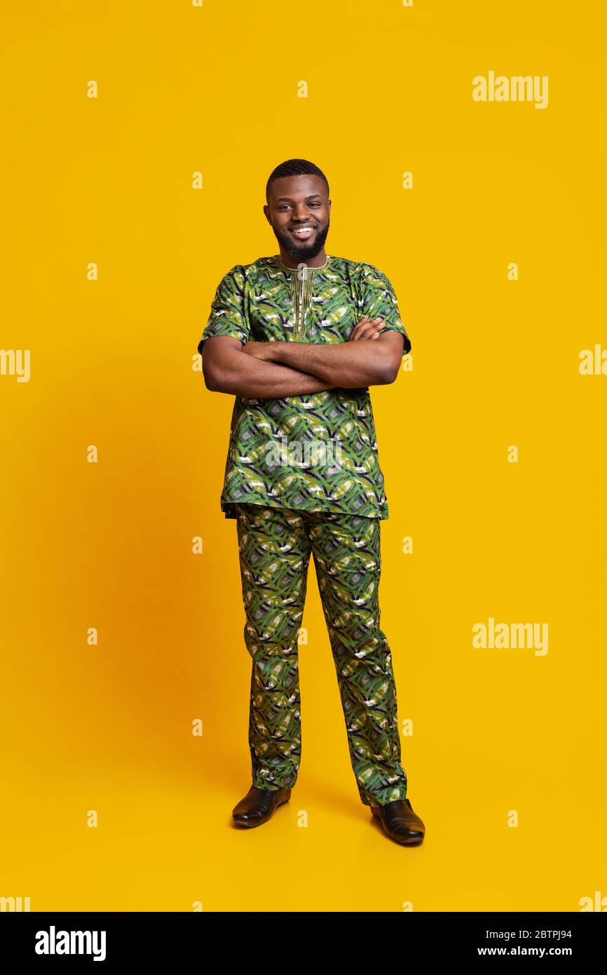 Lächelnder afrikaner in authentischem Kostüm posiert über gelbem Hintergrund Stockfoto