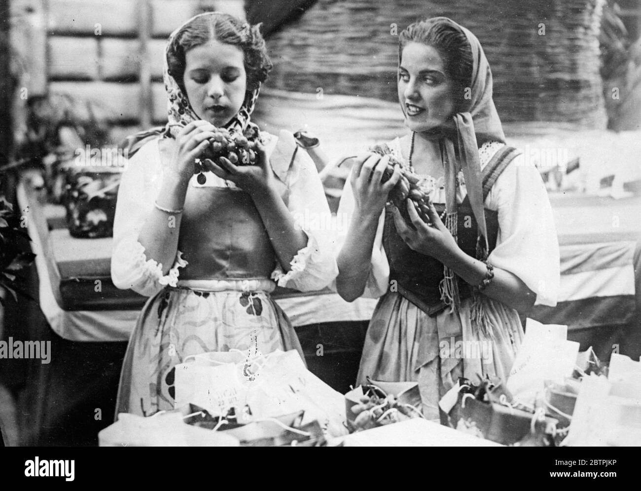Traubenfest im Tivoli . Das traditionelle Weinfest wurde in Tivoli, in Italien gefeiert. Foto zeigt zwei Mädchen in traditioneller Kleidung mit Trauben. September 1934 Stockfoto