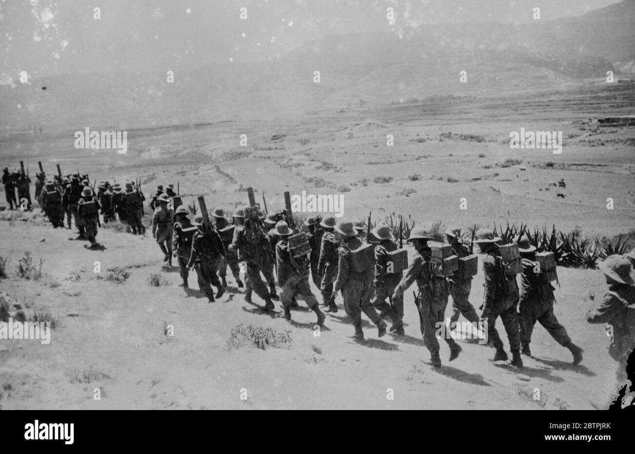 Truppen marschieren durch die Wüste . Eine Kolonne italienischer Truppen, die schwere Waffen und Ausrüstung auf dem Rücken tragen, die während des Vormarschs im Adigrat-Sektor durch die Wüste marschieren. 26. Oktober 1935 Stockfoto