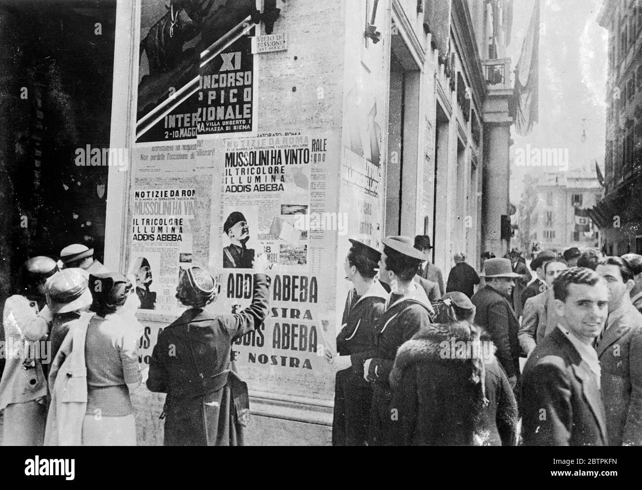 Tausende noch . Home liest über New Empire . Rom wurde mit Plakaten, die die Eroberung von Abessinien und die Anerkennung Signor Mussolini bedeckt. Foto zeigt, Leseplakate Ankündigung der Eroberung in Rom. Mai 1936 Stockfoto