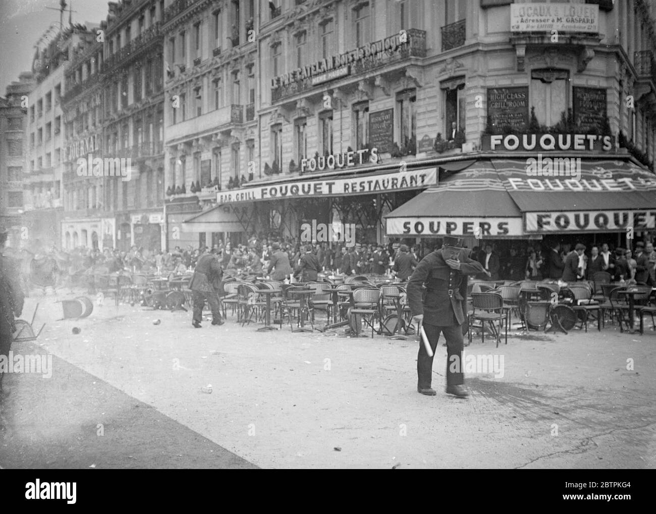 Casulty der Boulevards . 6, 000 Polizei und Wachen Club ihren Weg durch Paris Mobs, Frauen geschlagen. Viertausend Polizisten mit Fäusten und Schlagstöcken und 2, 000 mobile Wachen, die ihre Karbinen ausübten, knüppeln sich durch einen Mob, der sich am Grab des unbekannten Soldaten am Arc de Triumph in Paris versammelt. Männer, die mit der Polizei zu kämpfen hatten, wurden zu Boden geschlagen und mit Füßen getreten, und sogar Frauen und Kinder wurden in der Anklage angegriffen. Die Menge sang die marseillaise, als die Polizei ihren Angriff machte. Foto zeigt, in den Mund geschlagen, zieht sich ein Pariser Polizist aus dem f zurück Stockfoto