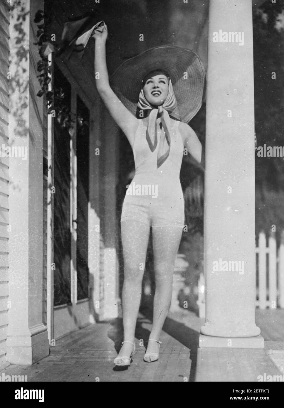Grüße an die Sonne . Grace Bradley, die Filmschauspielerin, begrüßt die zurückkehrende Sonne von der Säulenhalle ihres Hollywood-Hauses. 1936 Stockfoto