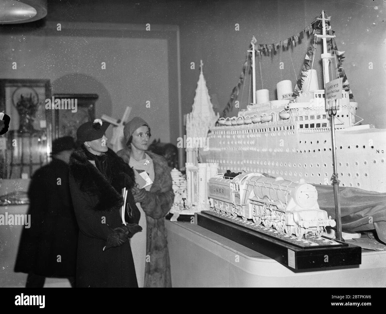 Die Normandie und Flying Scotsman in Meringue . Modelle des französischen Linienschiffes Normandie und des Flying Scotsman in Pastelleisung, auch bekannt als Meringue, sind im Hotel, Restaurant und Catering-Ausstellung Olympia zu sehen. Foto zeigt, die Vereisung Modelle der Normandie und der Flying Scotsman. 29. November 1935 1936 Stockfoto