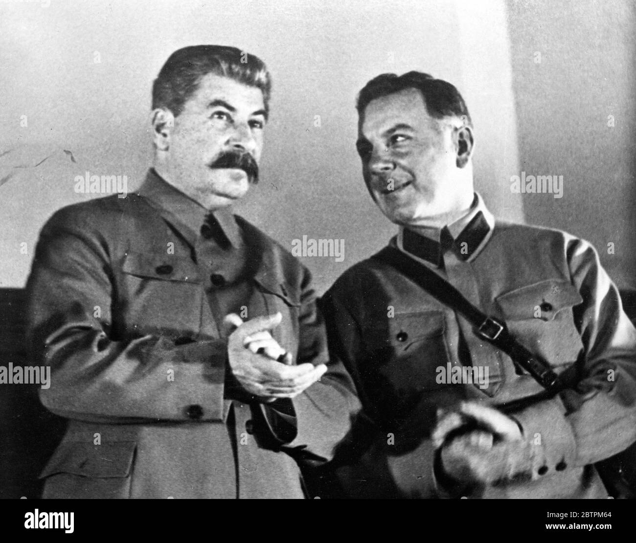 Stalin blickt nach vorne. Joseph Stalin, der sowjetische Diktator, fixiert seinen Blick nach vorne und klappt abwesend als lächelnd K E Woroshilow, Verteidigungskommissar. Macht einen Kommentar auf einer Arbeiterkonferenz im Kreml, Moskau statt. 28. November 1935 Stockfoto