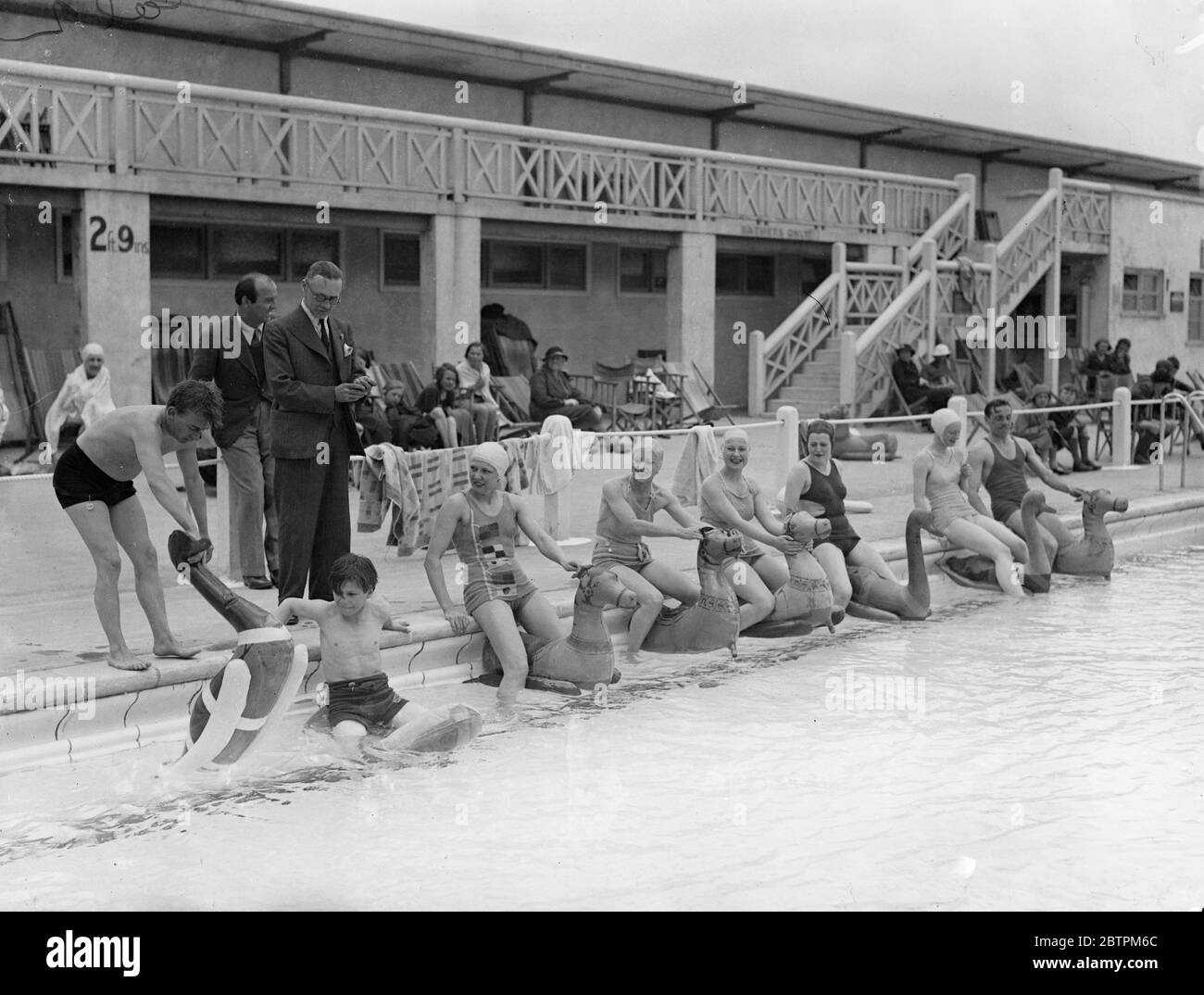 Pferderennen über Wasser . Schauspielerinnen nehmen an Wasser Karneval für Schauspieler profitieren die Gesellschaft . Schauspieler und Schauspielerinnen, darunter C B Cochren ' s Young Ladies, nahm an einem "Wasser Karneval" in Hilfe der "Schauspieler Benefit Society" am Lagoon Swimming Pool, Orpington Garden Village, Kent. Foto zeigt, Schauspielerinnen Schlange für ein "Pferderennen" im Wasser Karneval. Juni 1936 Stockfoto