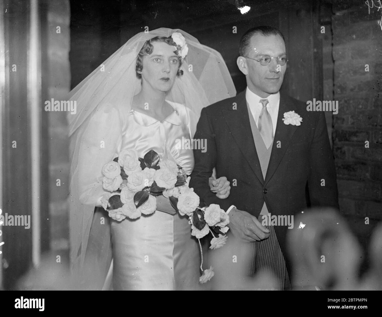 Die Enkelin des Millionärs heiratete in London. Sir Sidney Barton, ehemaliger britischer Minister in Addis Abeba, gab die Braut weg, als Meiss Sheila Mary Craven, Tochter des verstorbenen Gerald Craven, mit Herrn Francis Chichester in Chelsea Old Church, London verheiratet war. Der Bräutigam ist ein Enkel von Sir Arthur Chichester, und die Braut ein Cousin von Sir Charles Craven und Enkelin des verstorbenen Milliardärs Thomas Craven. Foto zeigt: Die Braut und der Bräutigam nach der Zeremonie. Die Braut trug einen außergewöhnlich großen Kopfschmuck. 25 Februar 1937 Stockfoto