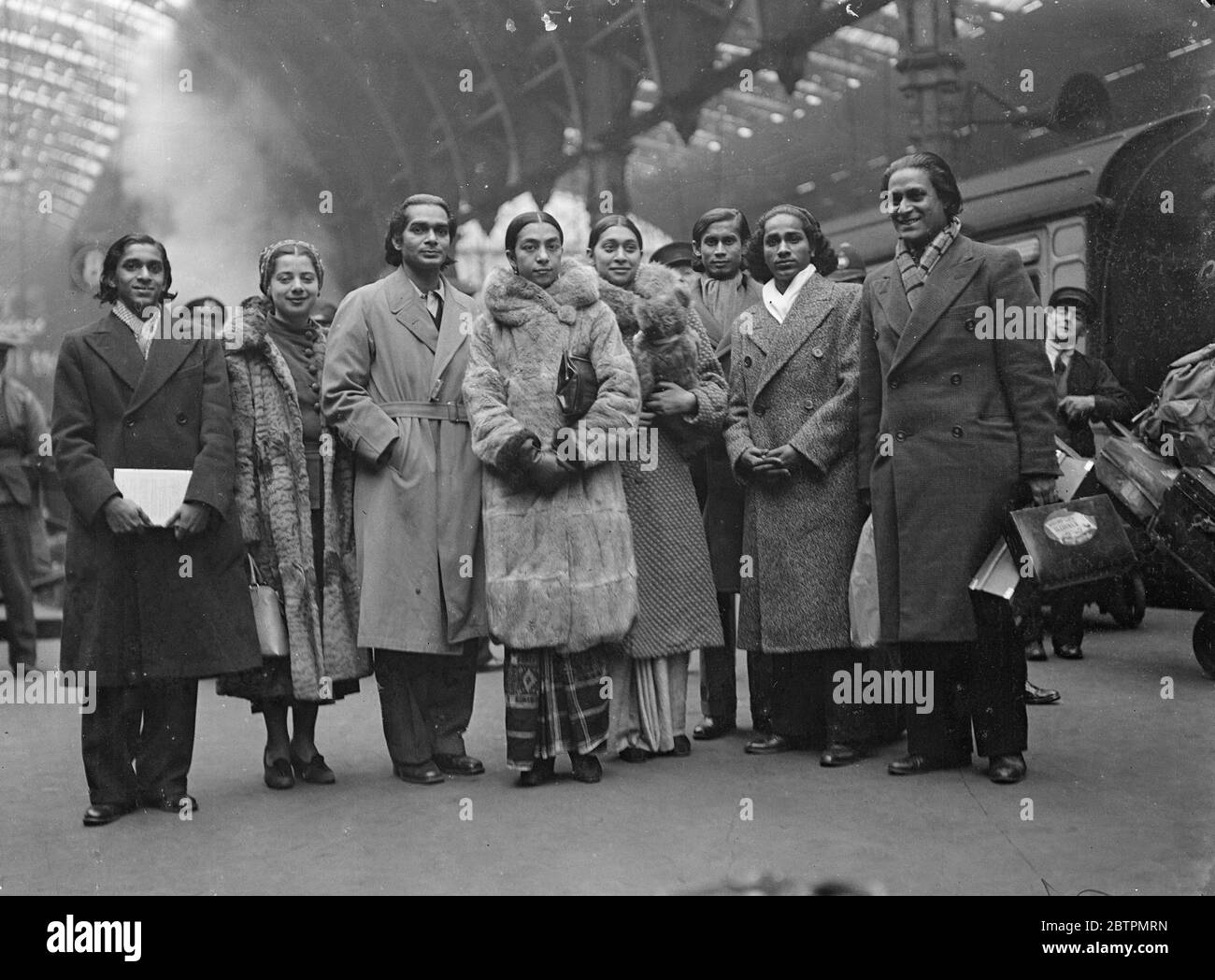 Hindu-Tänzerin kommt in London an. Uday Shan-Kar [Shankar] berühmter Hindu-Tänzer, kam mit seiner indischen Truppe mit dem Pariser Bootszug von New York am Bahnhof Paddington an. Die Tänzer werden am 9. März im Savoy Theater auftreten. Foto zeigt: Uday Shankar (dritter von links) und seine indischen Tänzer bei der Ankunft in Paddington. März 1937 Stockfoto