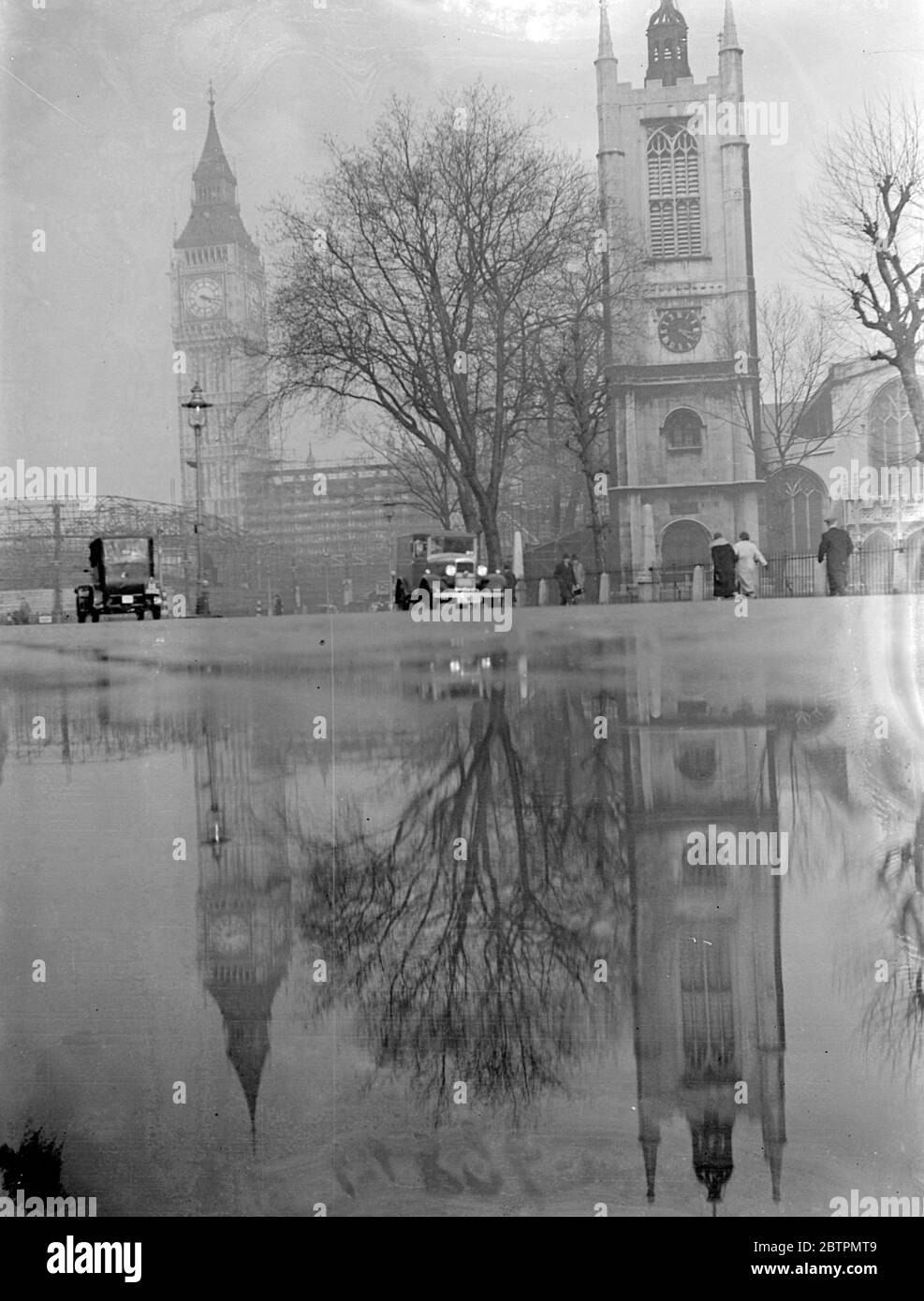 London hat sich verdoppelt. Ein paar verirrte Wellen von Abendsonne, die durch die Wolken glitten, machten dieses bemerkenswerte Spiegelbild von Big Ben und St. Margaret's in Westminster möglich. 25 Februar 1937 Stockfoto