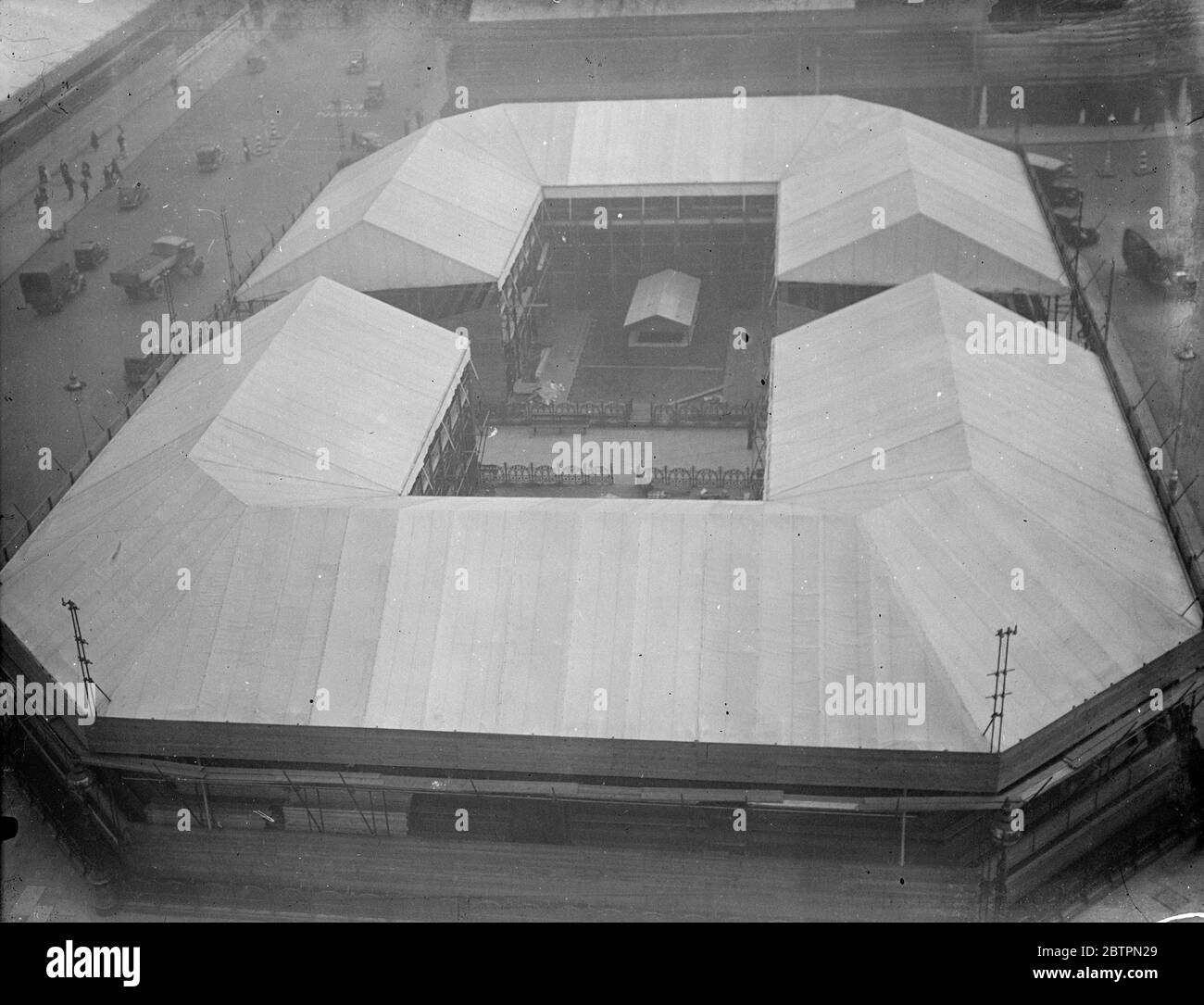 Krönungsarena. Eine Vogelperspektive auf die Krönungstribünen, die so etwas wie eine Sportarena aussehen, die jetzt das gesamte Zentrum des Parliament Square, Westminster, einnimmt. Diese Sitze bieten einen ausgezeichneten Blick auf die Prozession neue Westminster Abbey. 14. April 1937 Stockfoto