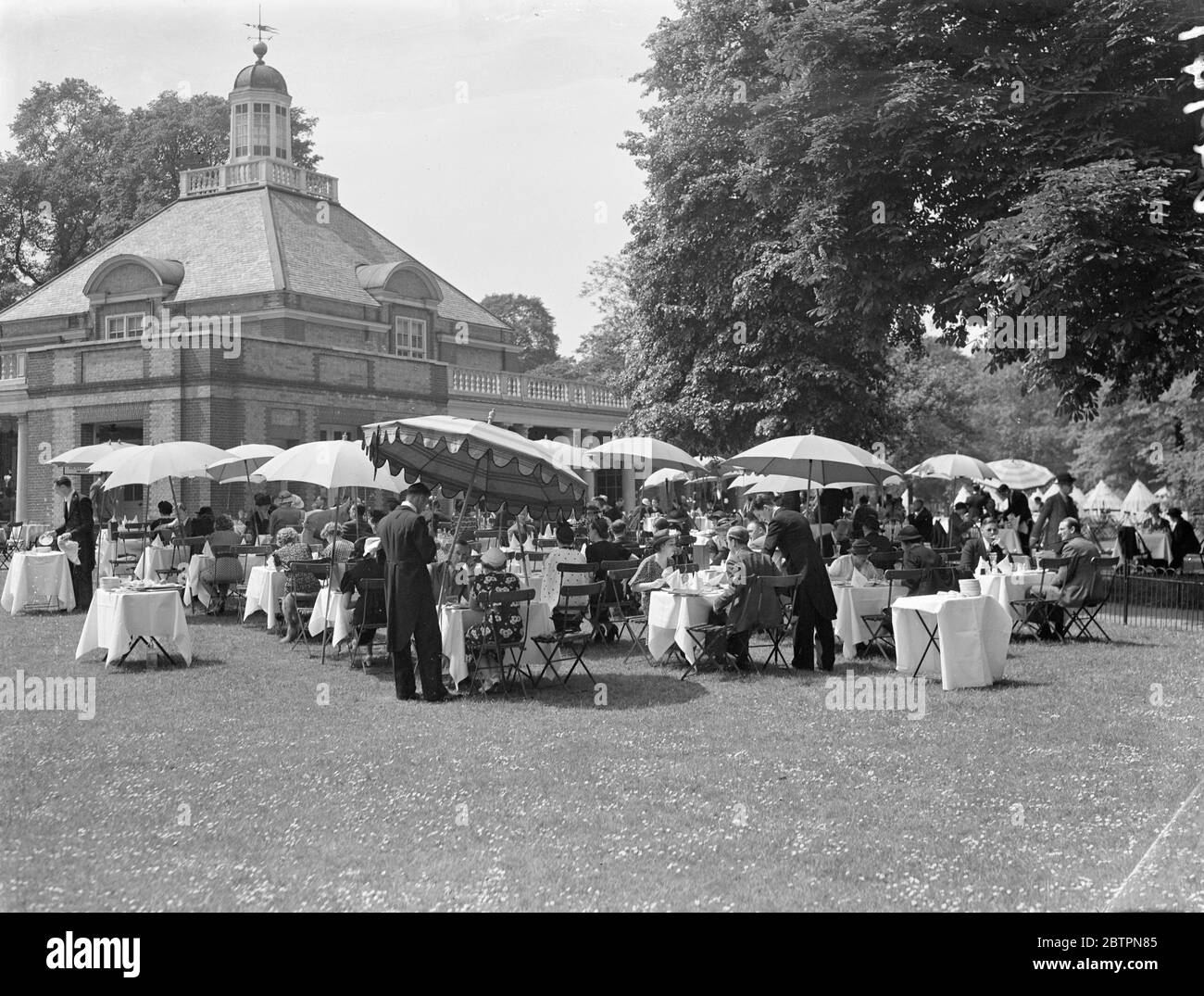 Die Hitzewelle kehrt nach London zurück. Die überfüllten Teegärten im Hyde Park, der das Lieblingsresort für Arbeiter in der Mittagszeit war, als die Hitzewelle mit voller Kraft nach London zurückkehrte. 28 Mai 1937 Stockfoto