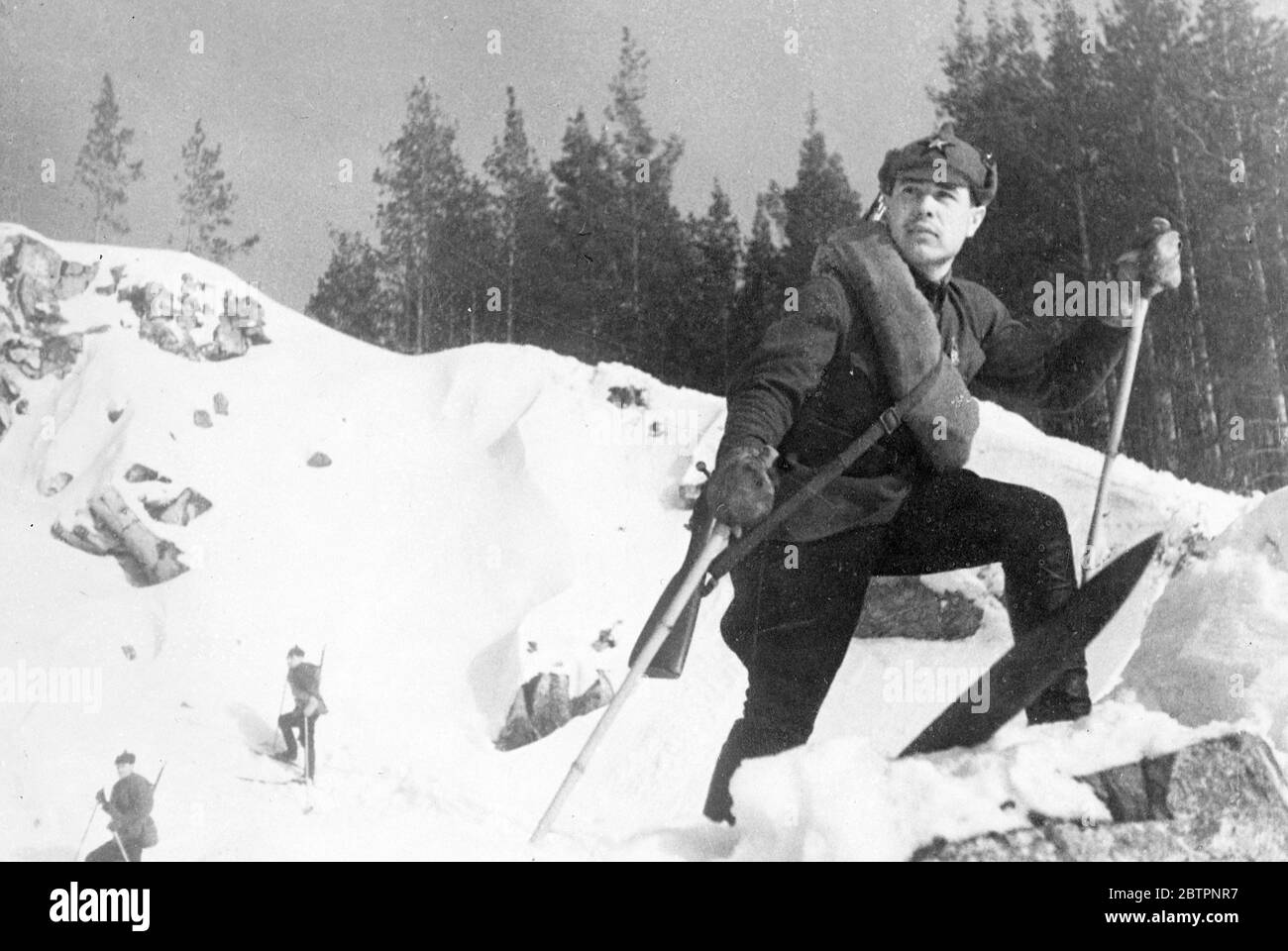 Soldaten des Schnees. Der Soldat der Roten Armee, der mit dem fünf-Punkte-Stern auf der Schulter aufgehängt ist, mit einer Decke und einem Gewehr, das über die Schulter geschleudert wird, blickt während der jährlichen sowjetischen Militärübungen über den Schnee des Urals. 13 Februar 1938 Stockfoto
