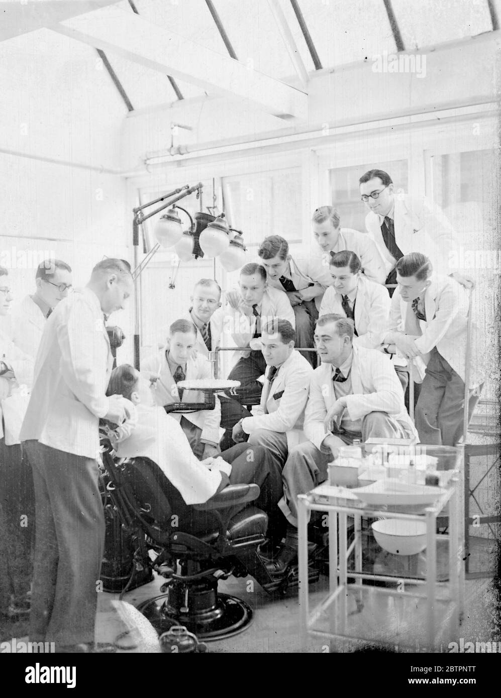 Der Massenangriff von Zahnschmerzen!. Diese Bilder wurden im Schutzraum der Guy's Hospital Dental School, London, aufgenommen, einer der Speerspitzen beim Angriff auf die Dämonenzahnschmerzen. Über 100 Patienten können in diesem Raum von Studenten der Zahnmedizin gleichzeitig betreut werden, der sich der Erhaltung der Zähne und nicht der Extraktion widmet. Sehr wenig Aufmerksamkeit wird auf sich genommen, obwohl ausschließlich Gold- und Silberfüllungen verwendet werden. Foto zeigt, eine genaue Inspektion eines Zahnes in der Guy's Hospital Dental School. Februar 1938 Stockfoto