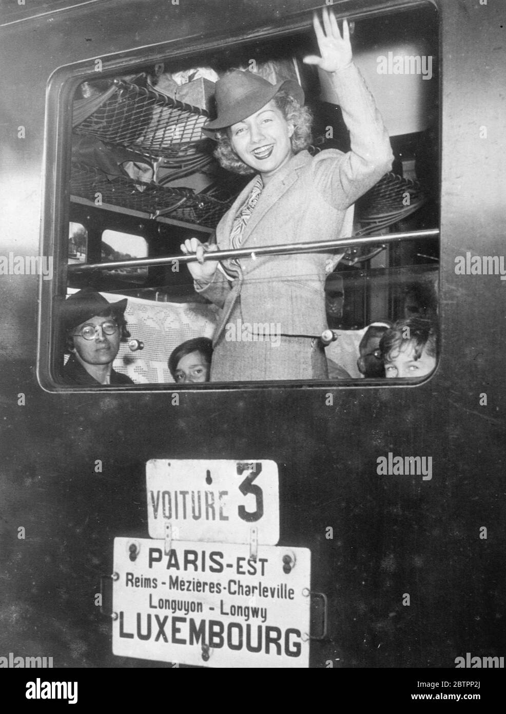 'miss Paris' winkt auf Wiedersehen. Miss Paris 1938 Privat Wehte Mlle Liliana fröhlich aus dem Kutschenfenster auf, als sie die Care du Nord in Paris verließ, um an den Feierlichkeiten dort teilzunehmen. Bis 28. August 1938 Stockfoto