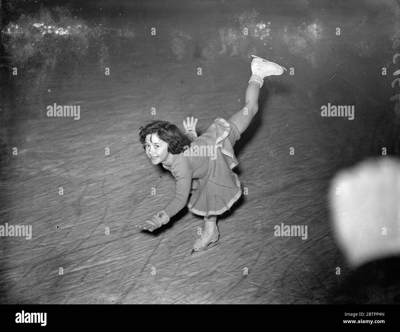 Fünf Fliegen. Beryl Bailey, der mit fünf Jahren ein versierter Skater ist, gibt eine Ausstellung auf dem Eis in der Harringay Arena, London. 28. Januar 1938 Stockfoto