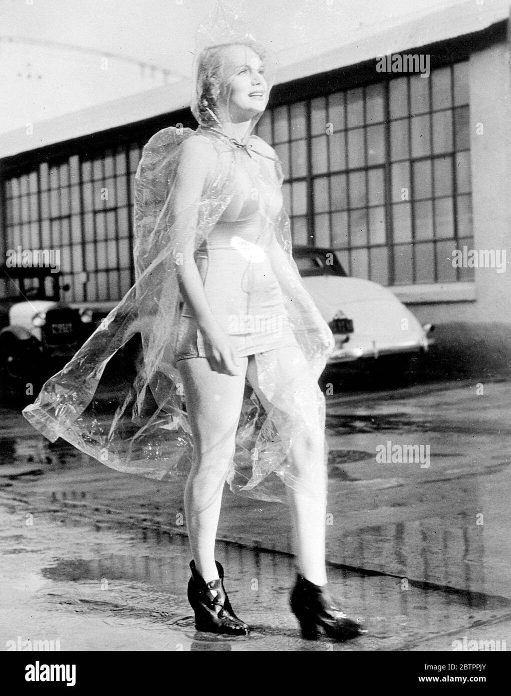 Der Wettermann hat das nicht durchgesehen! Marie Wilson, die Hollywood-Schauspielerin, schützt ihr modisches Badekleid mit diesem neuartigen Wet Weather Kostüm aus Zellophan. Ein Paar Galoschen komplettieren das Outfit. Kaliforniens kürzlich heftige Regenfälle inspirierten das neue Kostüm Stockfoto