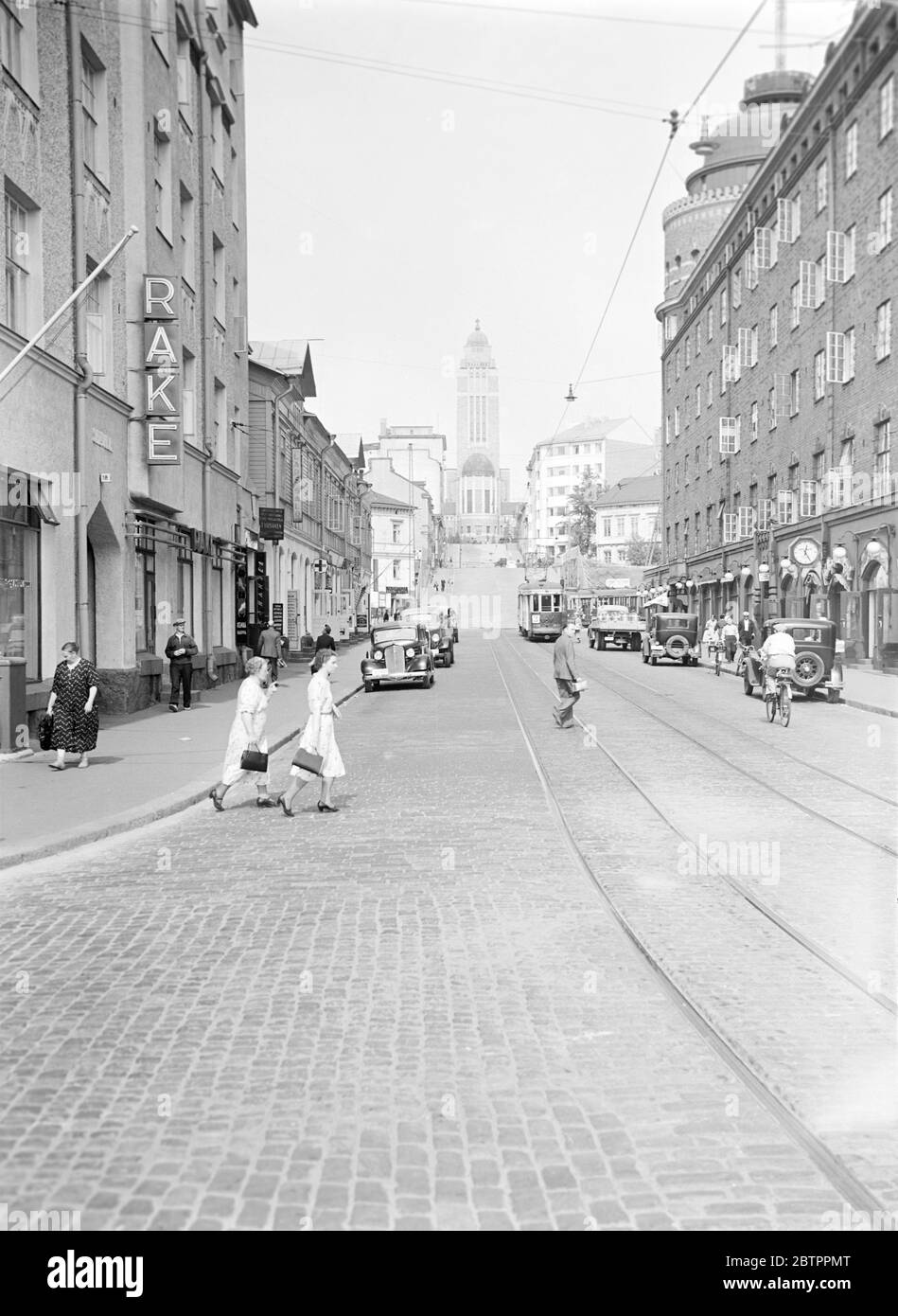 Helsinki und Persönlichkeiten. Wir von Siltasaarenkatu, einer der Hauptstraßen Helsinkis. Im Hintergrund die Kirche Ka Llio, eine der berühmtesten architektonischen Sehenswürdigkeiten der Stadt. Stockfoto