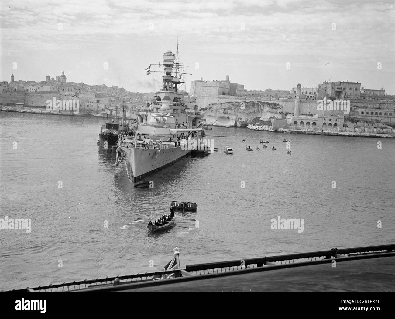 Das größte Kriegsschiff der Welt auf Malta. HMS Hood, das größte Kriegsschiff der Welt vor Anker im Hafen von Valletta, der Hauptstadt von Malta, wo Schiffe der britischen Marine vor dem Verlassen auf die kombinierten Übungen der Heimat-und Mittelmeer-Flotten, die auf den Südatlantik, aufgrund der Gefahr in spanischen Gewässern übertragen. Hinter "Hood" schwungvoll ist die Stadt Valletta, die viele Relikte der Besetzung der alten Ritter von Malta enthält. Dieses Bild wurde von 'HMS Courageous' aufgenommen, als der Flugzeugträger den Hafen betrate. März 1937 Stockfoto