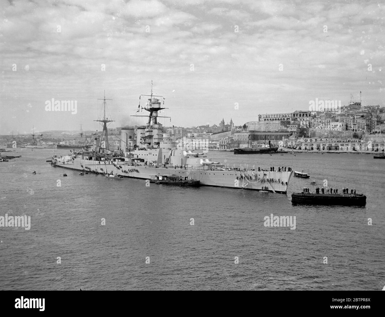 Das größte Kriegsschiff der Welt auf Malta. HMS Hood, das größte Kriegsschiff der Welt vor Anker im Hafen von Valletta, der Hauptstadt von Malta, wo Schiffe der britischen Marine vor dem Verlassen auf die kombinierten Übungen der Heimat-und Mittelmeer-Flotten, die auf den Südatlantik, aufgrund der Gefahr in spanischen Gewässern übertragen. Hinter "Hood" schwungvoll ist die Stadt Valletta, die viele Relikte der Besetzung der alten Ritter von Malta enthält. Dieses Bild wurde von 'HMS Courageous' aufgenommen, als der Flugzeugträger den Hafen betrate. März 1937 Stockfoto