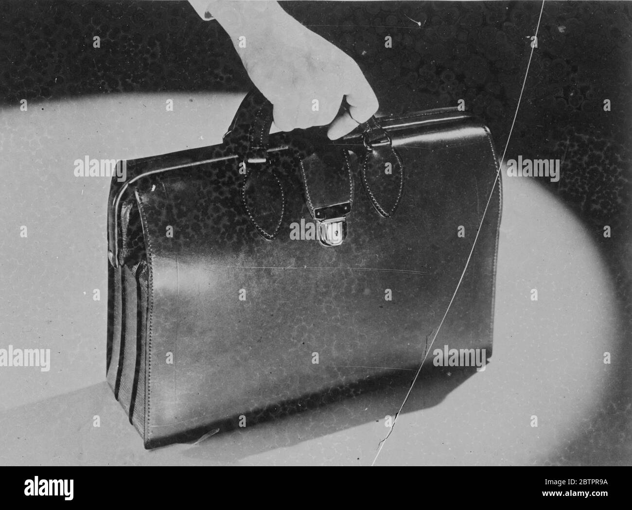 Eine Tüte voller Tricks. Bringt unangenehme Überraschungen für Bankräuber. Unschuldig im Aussehen, eine neue Tasche von amerikanischen Bankpassagiere verwendet ist so voller Überraschungen wie Zauberhut, und sie sind nicht halb so angenehm. Wenn der Bote von einem Dieb angegangen wird, setzt ein Paulus von einem kleinen Ring an der Tasche einen Mechanismus in Bewegung, der vier Schüsse abfeuert. Wenn der Beutel geknackt wird, kommt eine dichte Wolke aus gelbem Rauch aus ihm. Der Rauch ist harmlos. Im Freien, aber wenn der Robert die Tasche in ein Auto für einen Kurzurlaub trägt, werden die Dämpfe übermächtig und er wird gezwungen, raus zu gehen, die Tasche hinter sich zu lassen. Foto s Stockfoto
