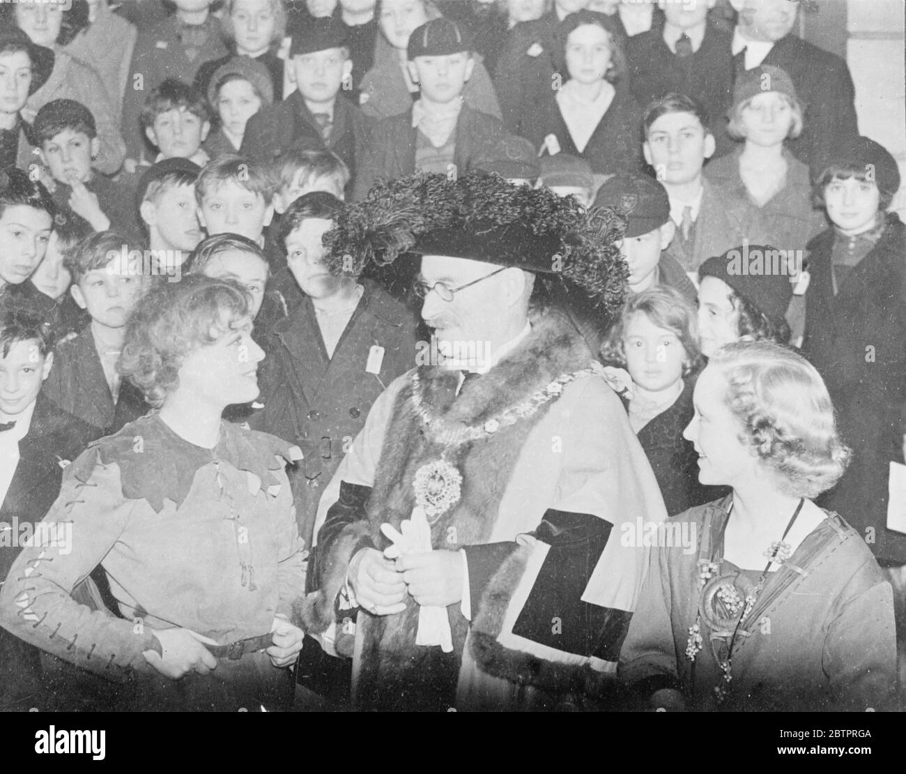 Oberbürgermeister trifft Peter Pan. Der Oberbürgermeister von London, Sir Harry Twyford, besuchte die Matinee-Aufführung von "Peter Pan", in der Anna Neagle die Hauptrolle spielt, im Londoner Palladium. Foto zeigt den Oberbürgermeister Sir Harry Twyford mit 'Peter Pan' (Anna Neagle) und 'Wendy' Pamela Stanley) auf der Matinee. 23 Dezember 1937 Stockfoto