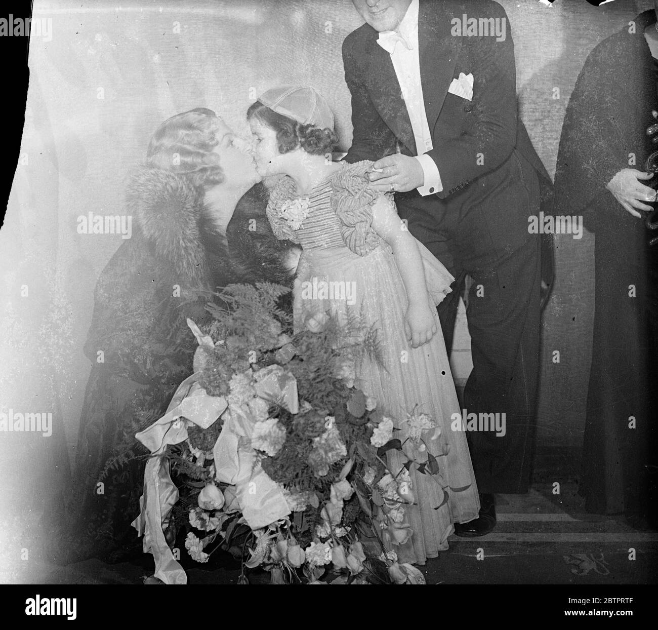 Kuss von Gracie Fields. Das New Prince of Wales Theater wurde eröffnet. Gracie Fields, der Komiker, eröffnet Londons neuestes Theater, das wiederaufgebaute Prince of Wales, in der Coventry Street. Das neue Theater, das bereits als Heimat von Londons Folics Bergare bezeichnet wurde, wurde in etwas mehr als neun Monaten komplett umgebaut. Foto zeigt, Gracie Fields belohnt mit einem Kuss kleine Miss Clora, die ihr mit einer Fliege bei der Eröffnungszeremonie überreicht. 27. Oktober 1937 Stockfoto